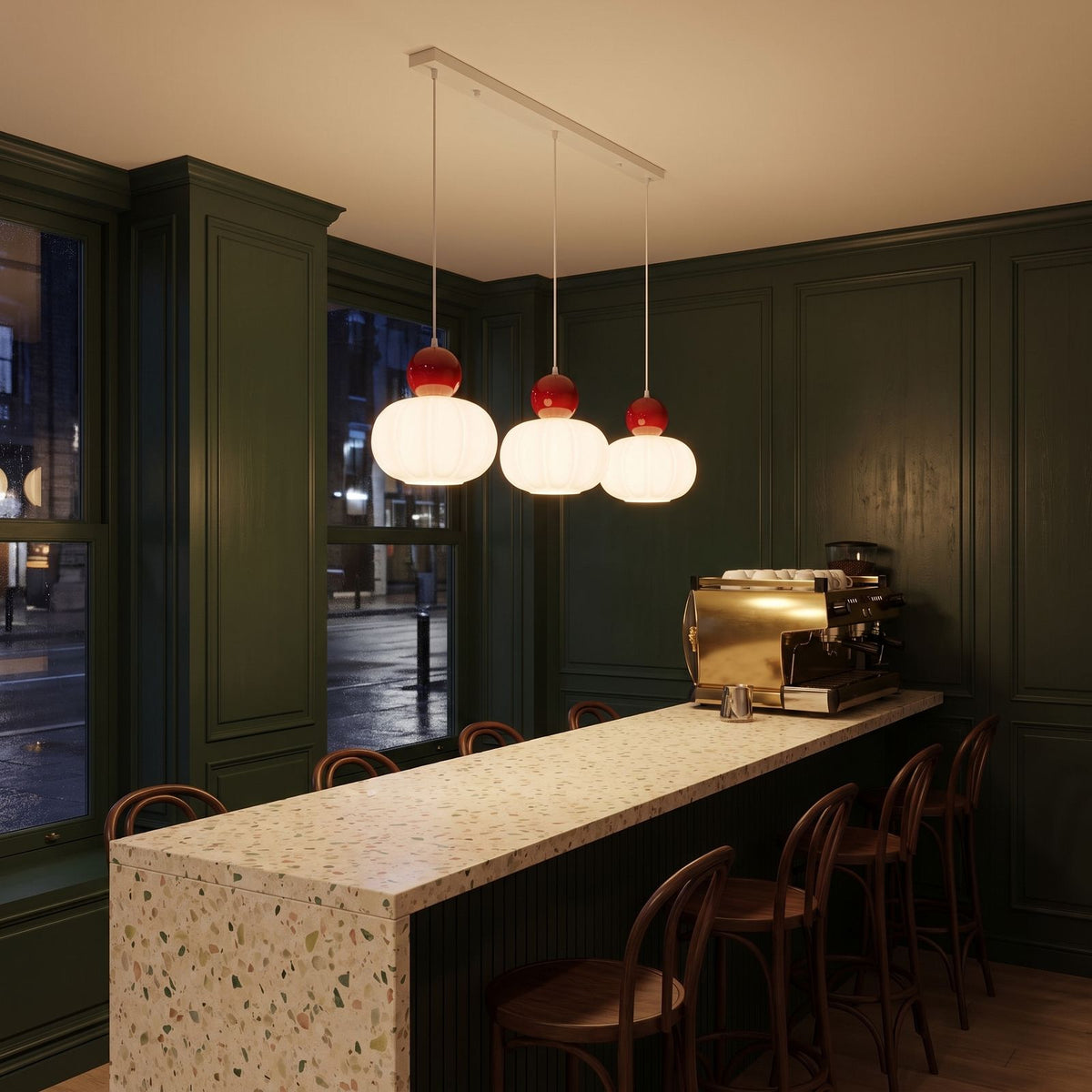 Ball-top scalloped acrylic 3-light pendant lit in warm white above a cafe counter at night