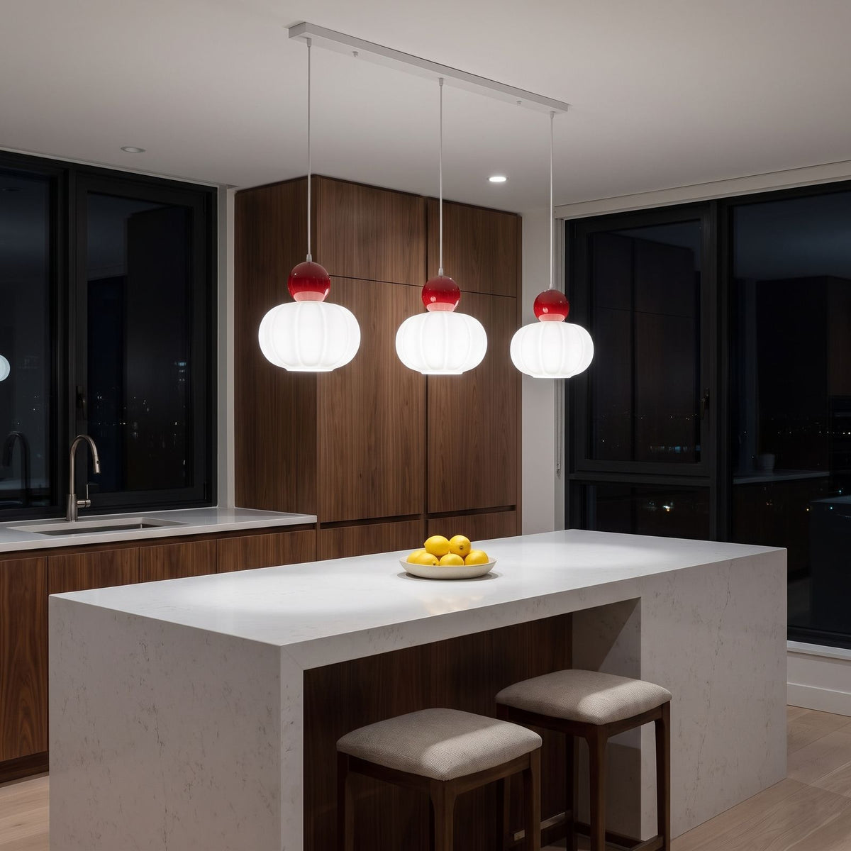Ball-top scalloped acrylic 3-light pendant lit in natural white above a kitchen island at night