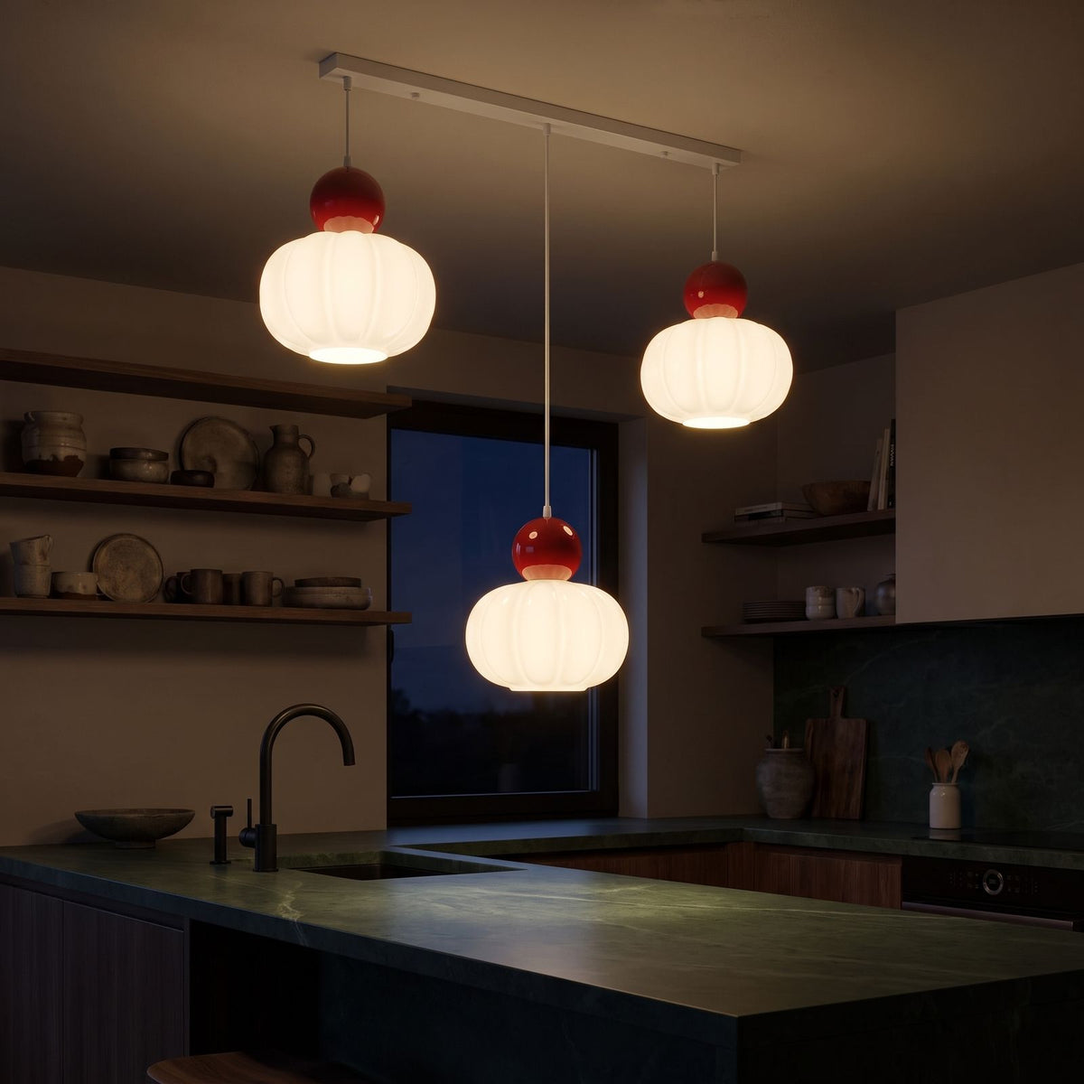 Ball-top scalloped acrylic 3-light pendant lit above a dark green stone kitchen island, centre shade hung lower