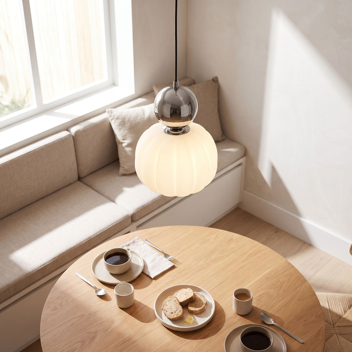 Ball-top scalloped acrylic pendant light over a breakfast table in daylight