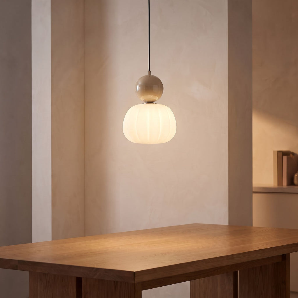 Ball-Top Scalloped Acrylic Pendant Light with a beige ball above a dining table