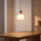 Ball-Top Scalloped Acrylic Pendant Light with a beige ball above a dining table