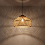 Bamboo Rattan Dome Pendant Light glowing against a plaster wall at night