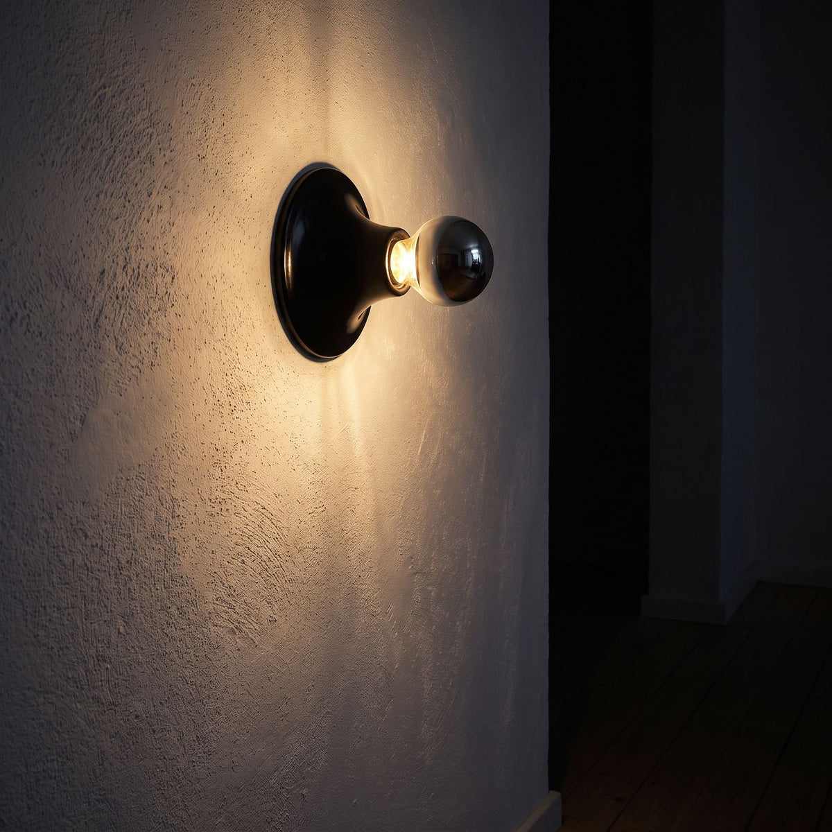 Bauhaus Retro Iron Wall Light glowing on a plaster wall at night