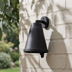 Bell Shade Aluminium Outdoor Wall Light on a painted brick wall, angled close view