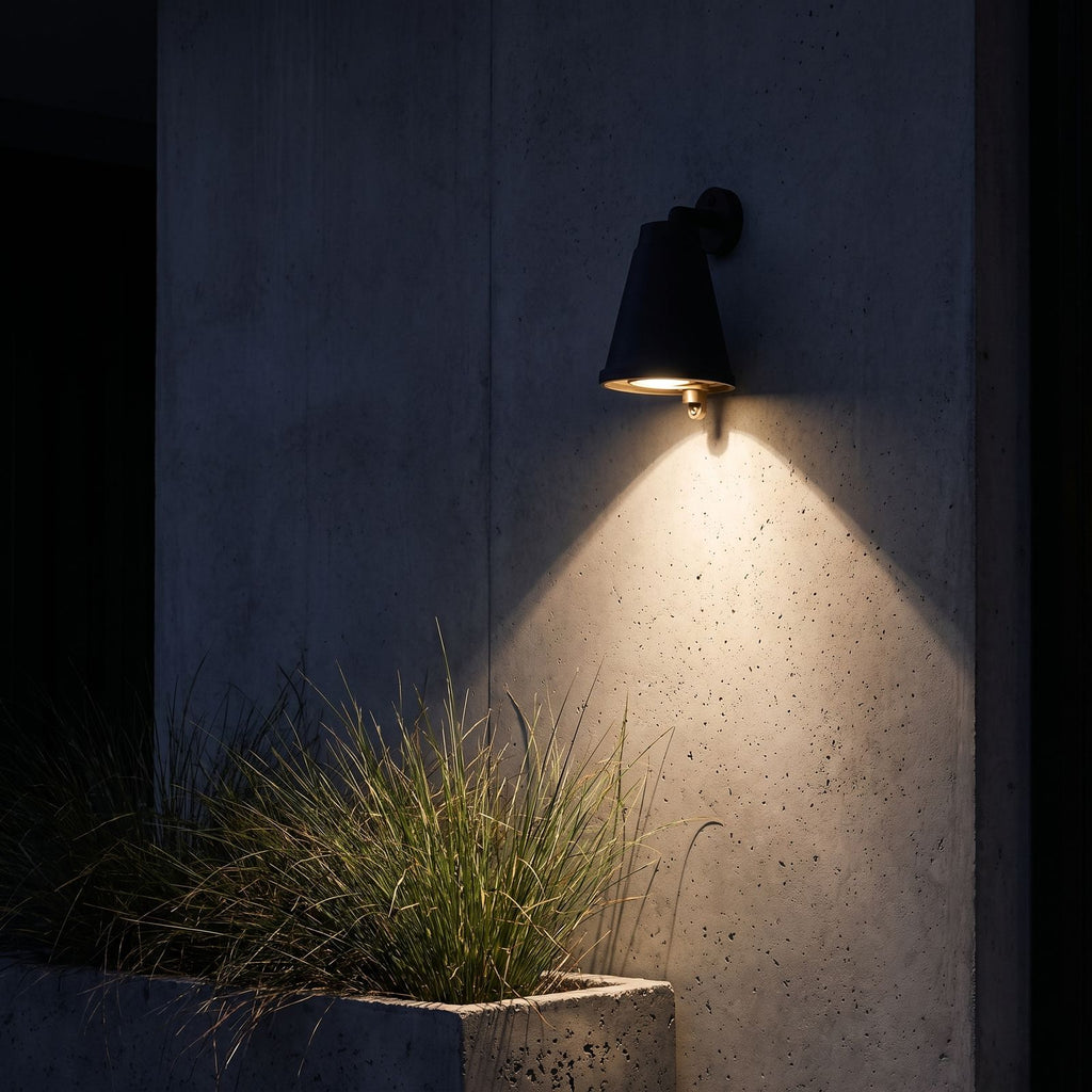 Bell Shade Aluminium Outdoor Wall Light lighting a concrete wall at night