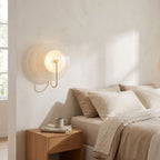 Bent Rod Round Glass Wall Light on a bedroom wall beside the bed