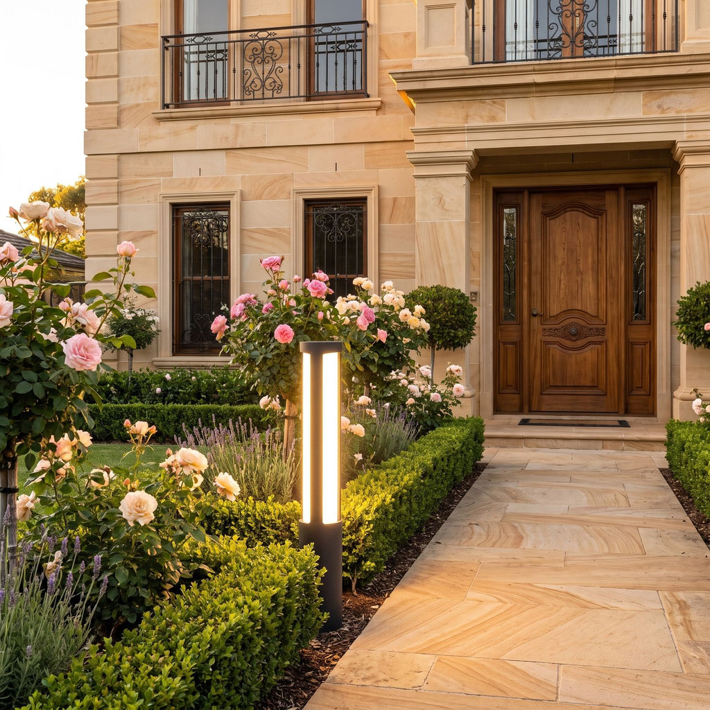 Black Aluminium Cylinder White Diffuser LED Bollard Light beside a front garden path at golden hour