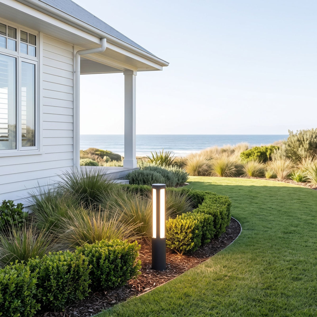 Black Aluminium Cylinder White Diffuser LED Bollard Light beside a driveway in daylight