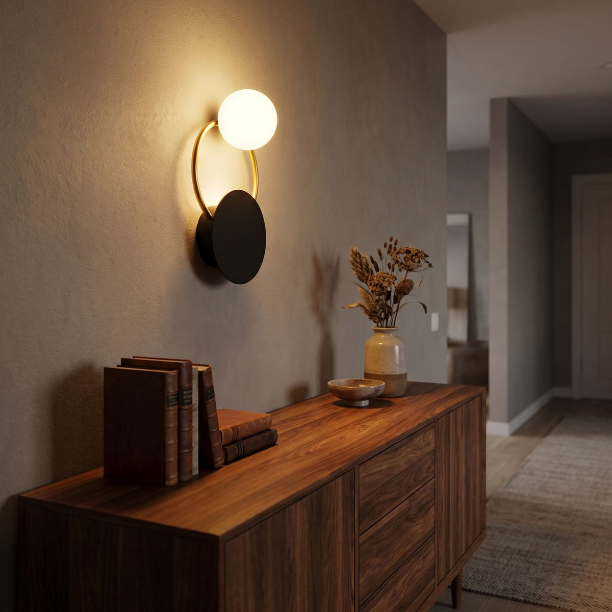Black Disc, Gold Ring and Glass Orb Wall Light in a hallway above a timber console