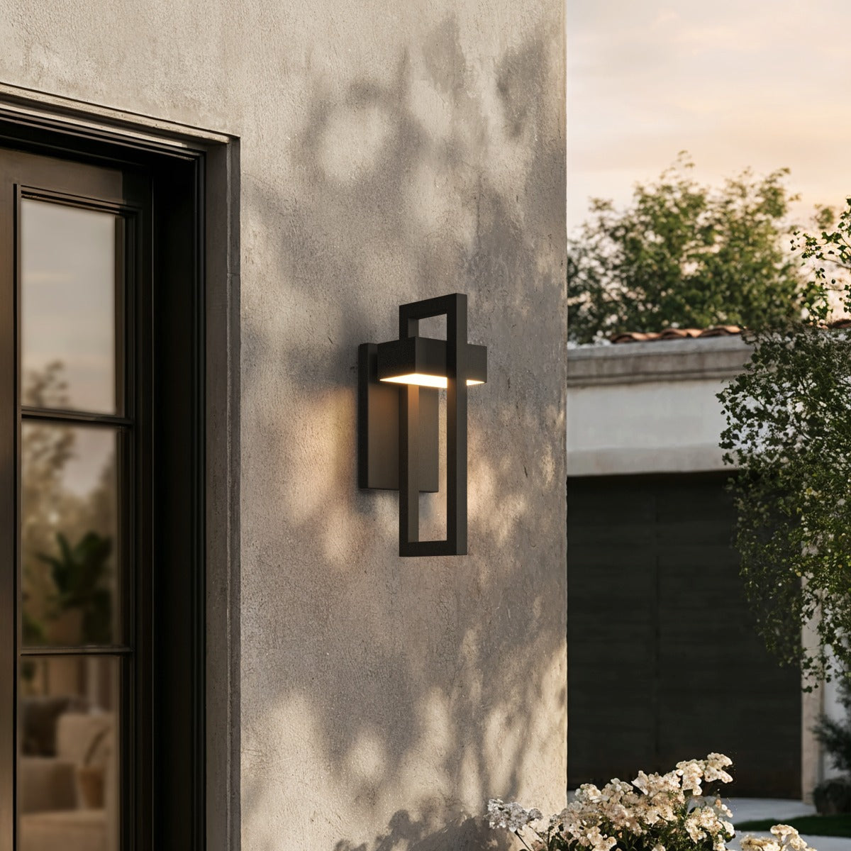 Outdoor wall sconce washing warm light down a pale exterior wall