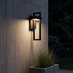 Black Frame Outdoor Wall Sconce lighting a concrete wall at night