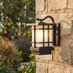 Black Iron and Frosted Glass Outdoor Wall Lantern, close view at 45 degrees on a stone wall