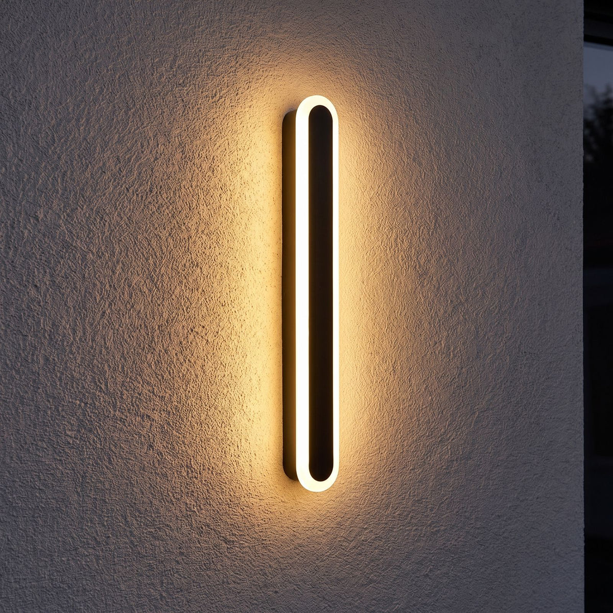 Black Oval Linear LED Outdoor Wall Light on a porch wall at dusk