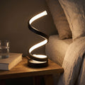 Black Spiral Ribbon LED Table Lamp on a bedside table