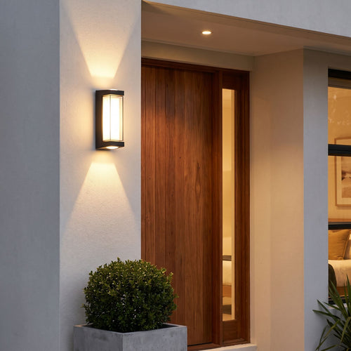 Black Up Down Outdoor Wall Light beside a front door at dusk