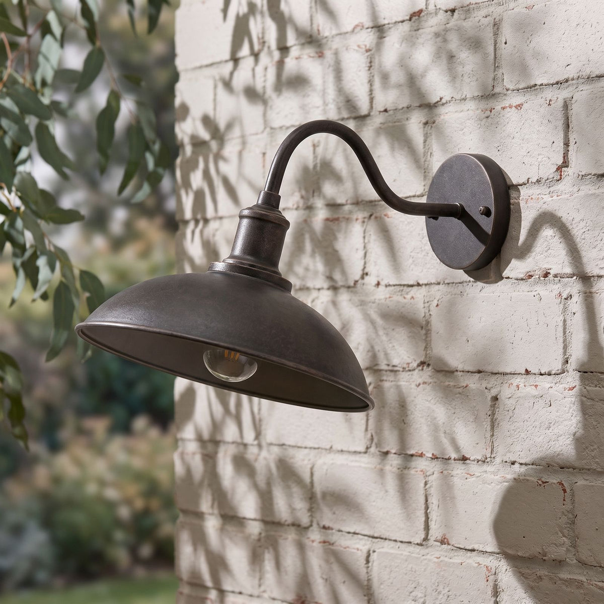 Bowl Shade Gooseneck Outdoor Wall Light on a painted brick wall, angled close view