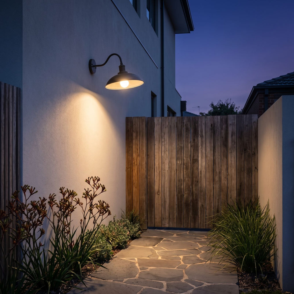 Bowl Shade Gooseneck Outdoor Wall Light on a rendered side wall beside a timber gate at dusk