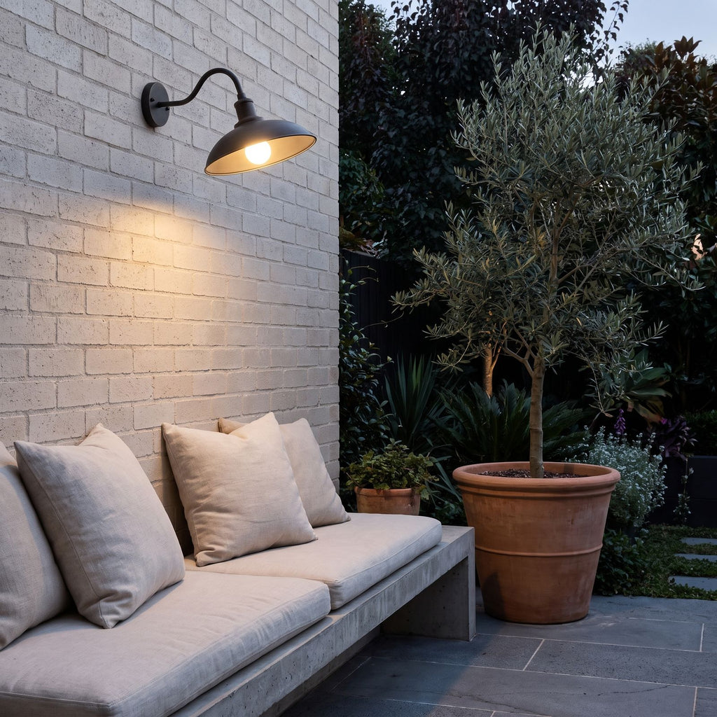 Bowl Shade Gooseneck Outdoor Wall Light above a concrete bench on a brick courtyard wall