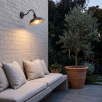 Bowl Shade Gooseneck Outdoor Wall Light above a concrete bench on a brick courtyard wall