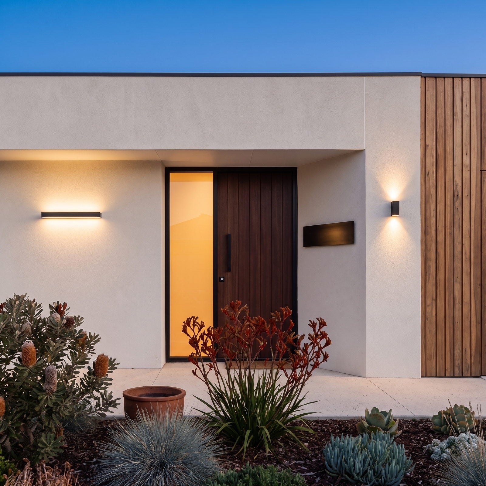 Two different LumePorch outdoor wall lights at the entry of a contemporary Australian home at dusk