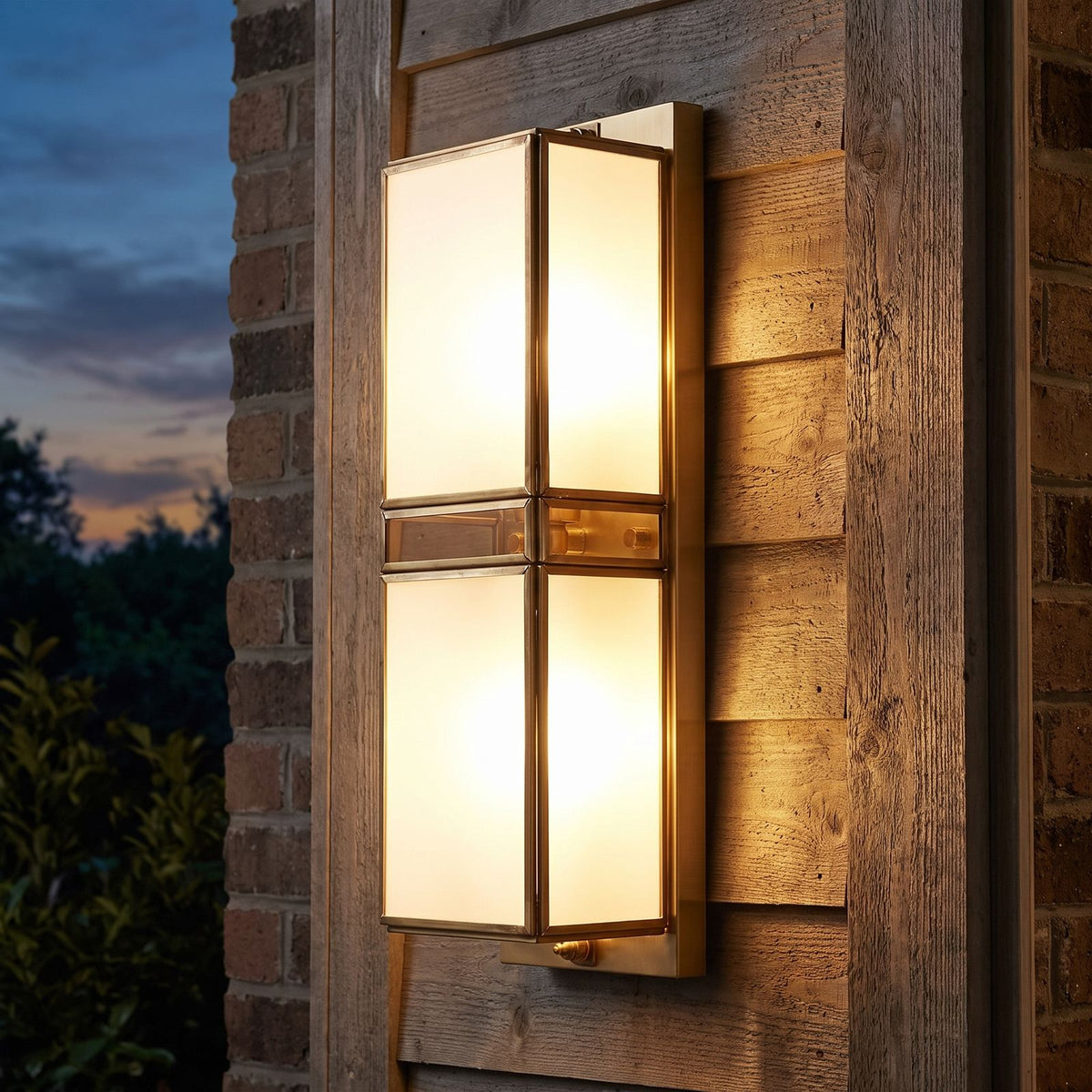 Brass and White Glass Outdoor Wall Light on a porch wall at dusk