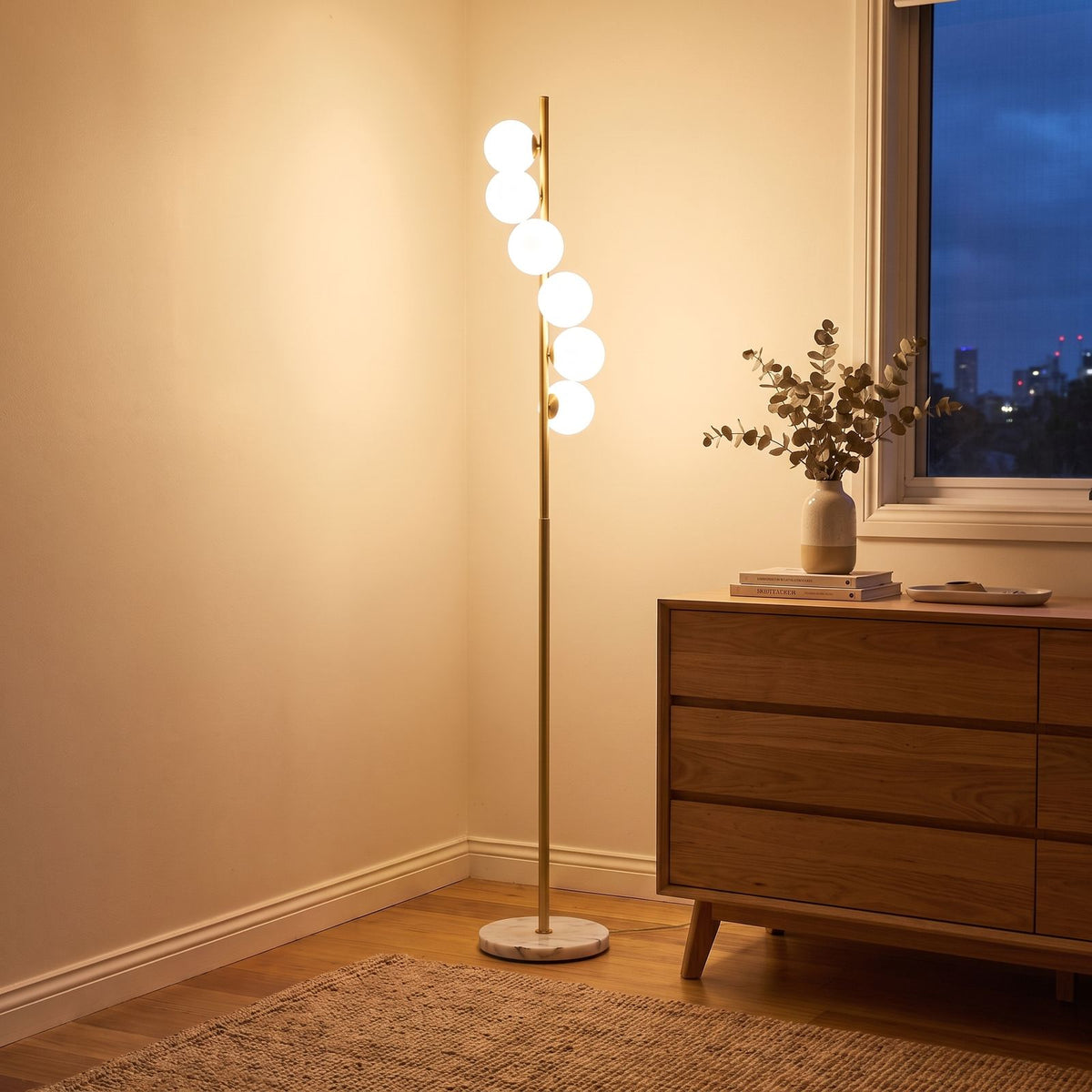 Brass finish opal glass globe floor lamp in a bedroom corner beside a dresser