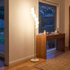 Brass finish opal glass globe floor lamp beside an entry hall console