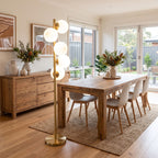 Brass Finish 6-Light Opal Glass Globe Floor Lamp above a dining table