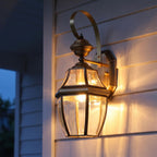 Brass Lantern Outdoor Wall Light on a porch wall at dusk