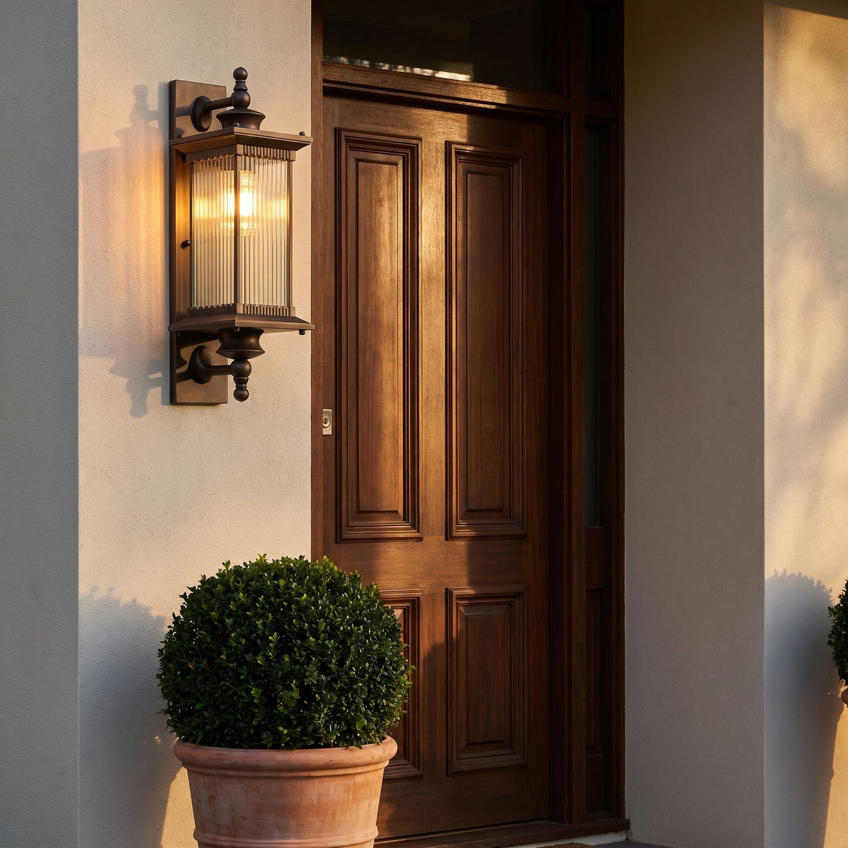 Bronze Reeded Glass Outdoor Wall Lantern beside a timber panelled front door