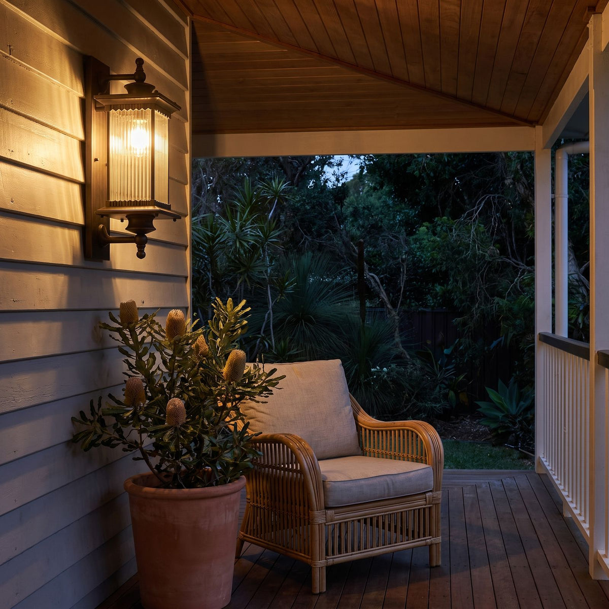 Bronze Reeded Glass Outdoor Wall Lantern on a weatherboard veranda wall at dusk
