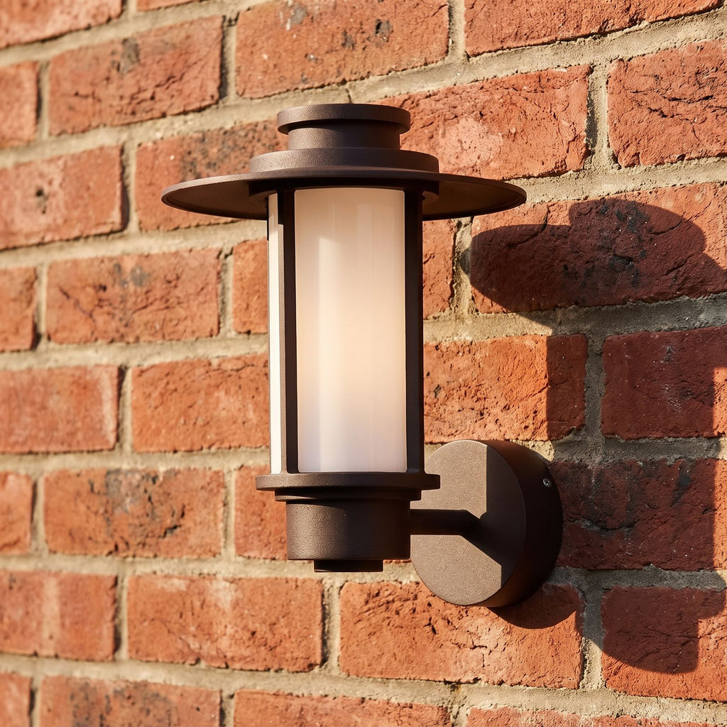 Brown Iron and Acrylic Lantern Outdoor Wall Light, close view at 45 degrees on a stone wall
