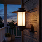Brown Iron and Acrylic Lantern Outdoor Wall Light on a porch wall at dusk