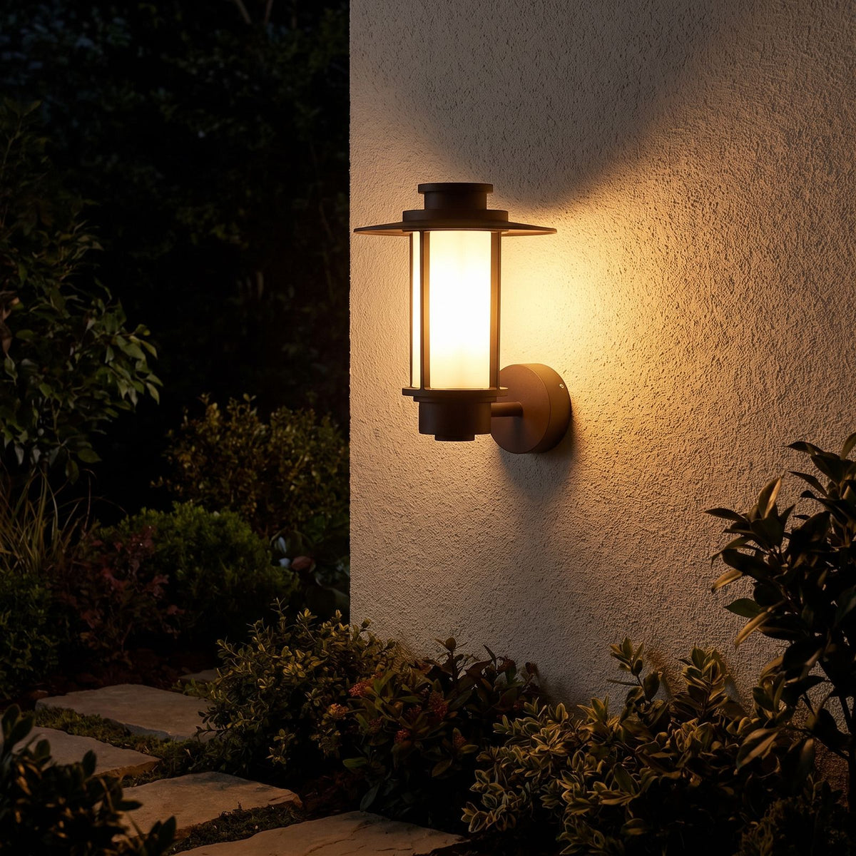 Brown Iron and Acrylic Lantern Outdoor Wall Light glowing on a garden wall at night