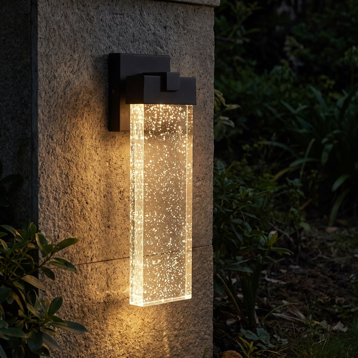 Bubble Acrylic Column Outdoor Wall Light glowing on a garden wall at night