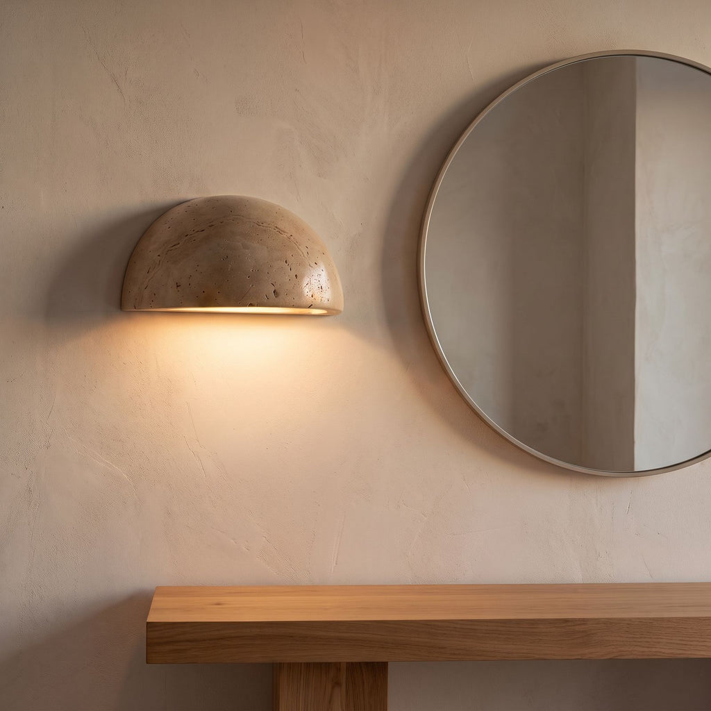 Stone half dome LED wall light beside a round mirror in an entry hall