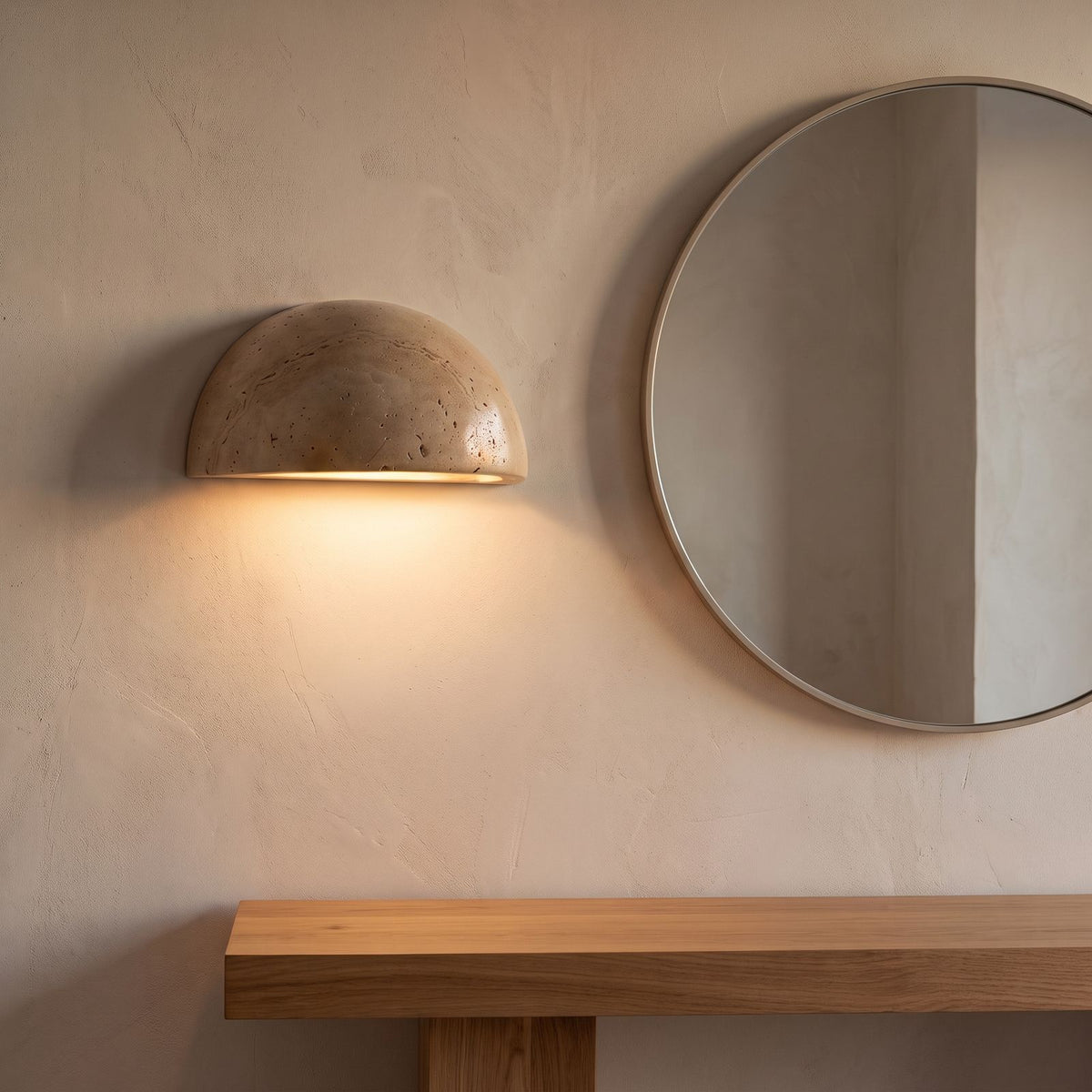 Stone half dome LED wall light beside a round mirror in an entry hall