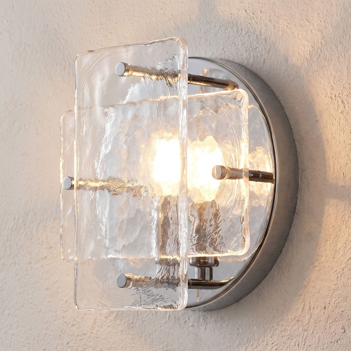 Chrome Frame Round Glass Wall Light, close view at 45 degrees on a plaster wall