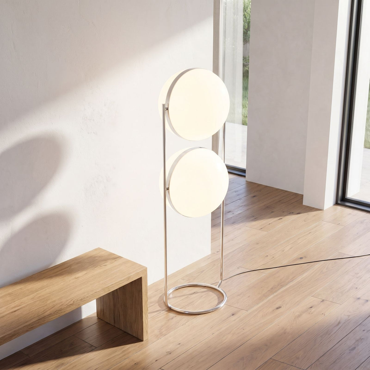 Chrome ring double globe floor lamp beside an entry hall bench in daylight