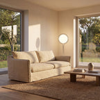 Chrome ring acrylic globe floor lamp behind a sofa, wide living room view