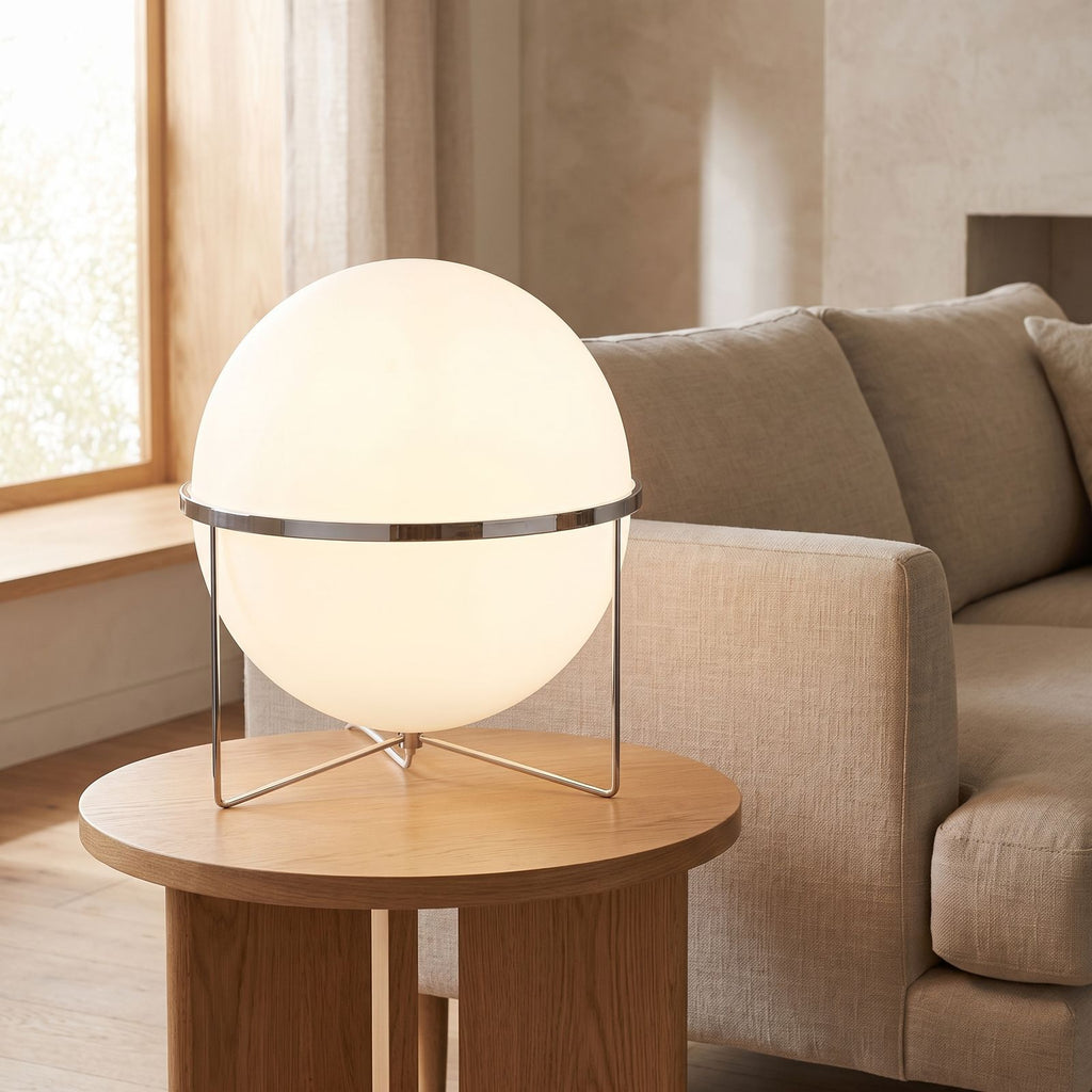 Chrome ring acrylic globe table lamp on a side table beside a sofa in daylight