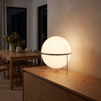 Chrome ring acrylic globe table lamp on a sideboard at night