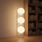 Chrome ring triple globe floor lamp in a reading corner at night