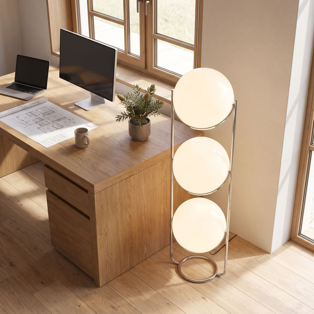 Chrome ring triple globe floor lamp beside a home office desk in daylight