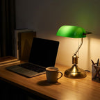 Classic Bankers Table Lamp lit beside a laptop on a desk at night