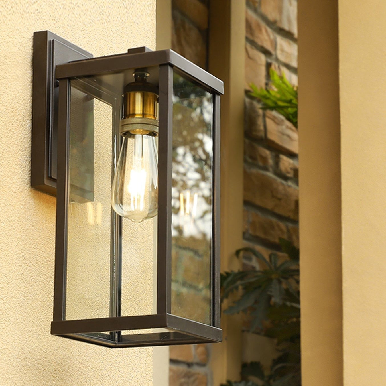Clear glass lantern wall light on a warm rendered wall