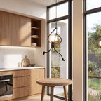 Climbing figure iron pendant light over a kitchen table in daylight