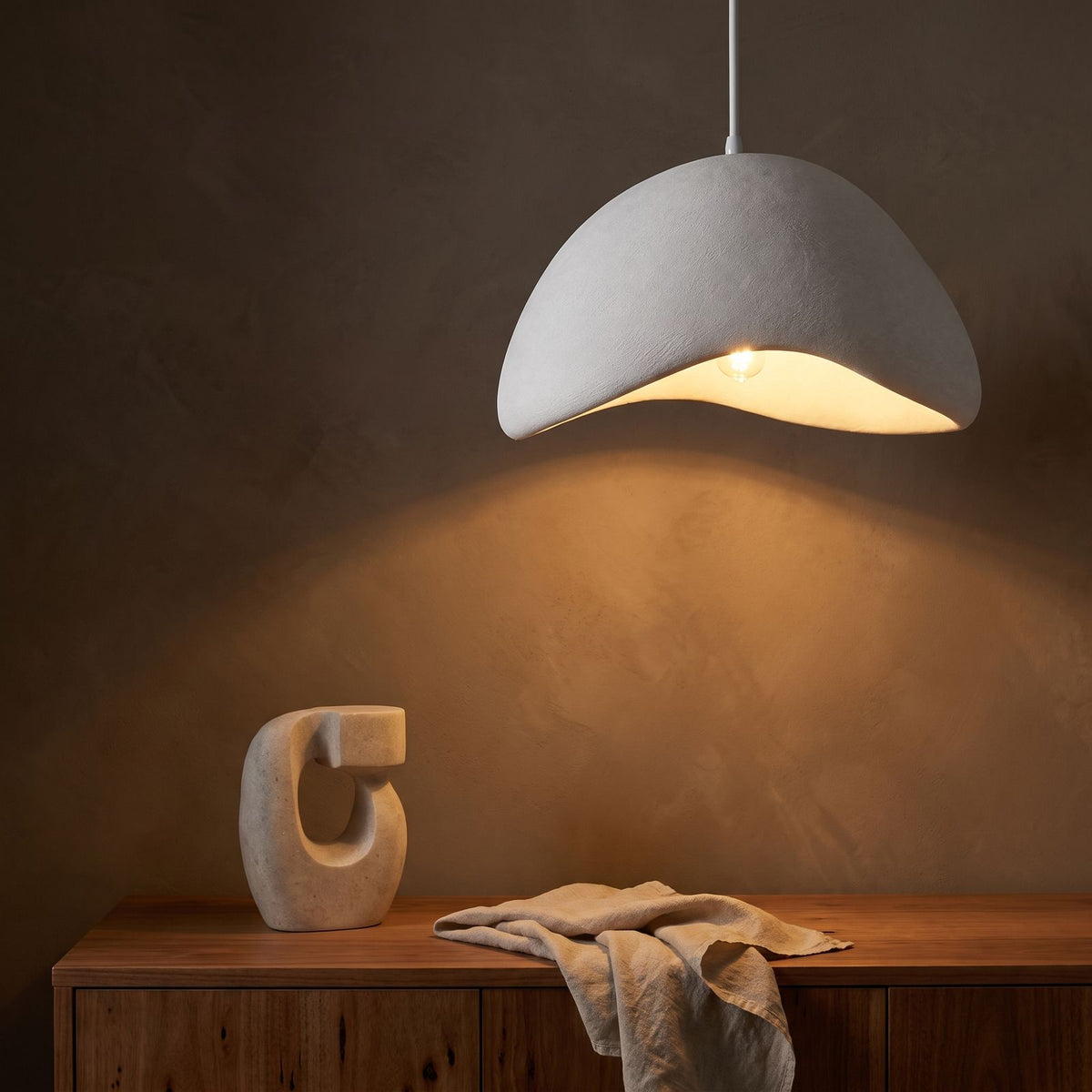 Cloud Shaped Japandi Pendant Light glowing against a plaster wall at night