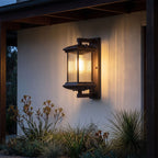 Fluted glass outdoor wall lantern lit on a rendered veranda wall at night